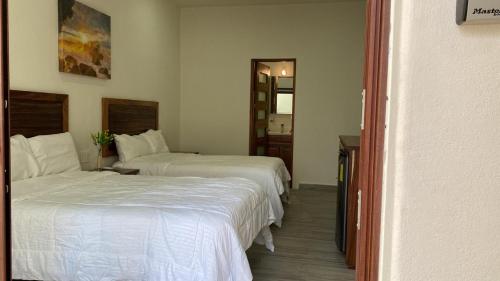Un dormitorio con dos camas y un espejo. en San pancho bungalows, en San Francisco