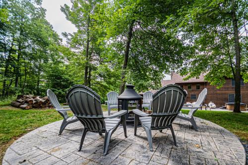 four chairs and a table with a lantern on a patio at Dancing Bear Lodge in McHenry