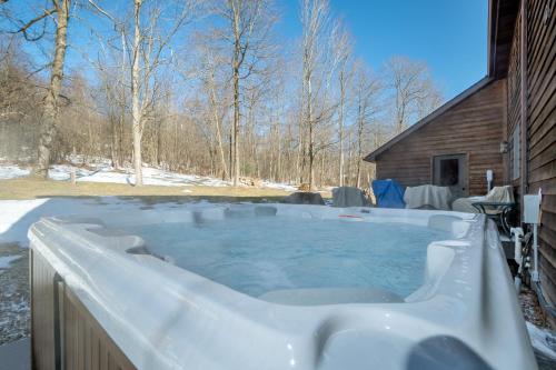 a hot tub covered in snow next to a cabin at Dancing Bear Lodge in McHenry