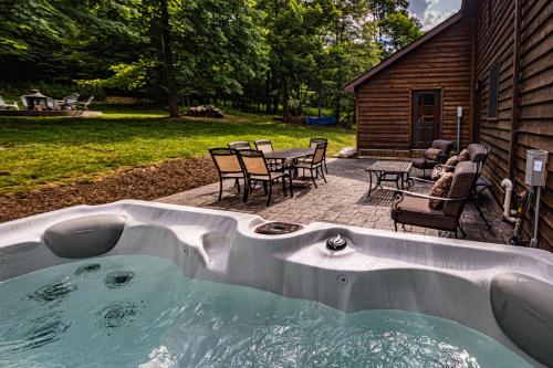 a hot tub in a backyard with a table and chairs at Dancing Bear Lodge in McHenry