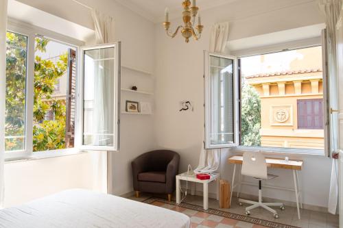 a bedroom with a bed and a desk and windows at Luxury Borghese Magnolia Suite in Rome