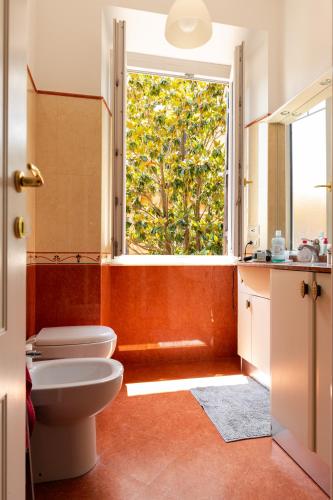 a bathroom with a toilet and a large window at Borghese Magnolia Suite in Rome