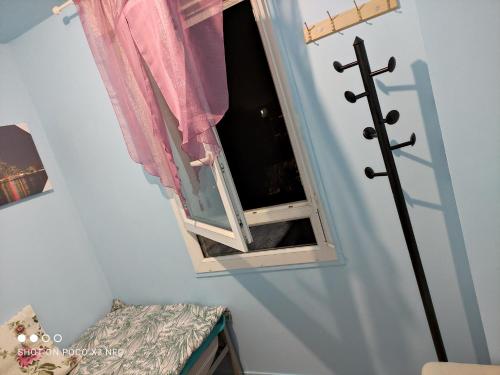 une pièce avec une fenêtre et une croix sur le mur dans l'établissement Nice Private Room Paris City20mn&cdg10mn chambre prive, à Sevran