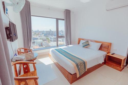 a bedroom with a bed and a large window at Luxury hotel Phú Yên in Liên Trì (3)