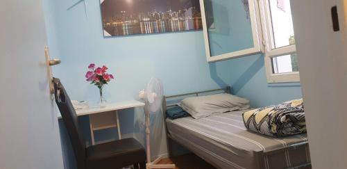 Cette petite chambre comprend un lit, un bureau et une chaise. dans l'établissement Nice Private Room Paris City20mn&cdg10mn chambre prive, à Sevran