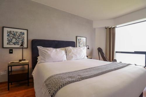 Un dormitorio con una gran cama blanca y una ventana en Industrial 3BR With OCEAN View, en Lima