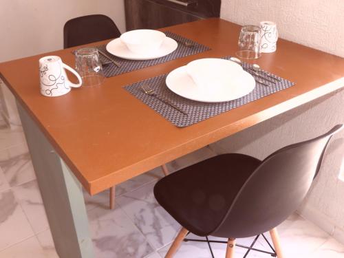 a wooden table with plates and dishes on it at Green Lofts in Cancún