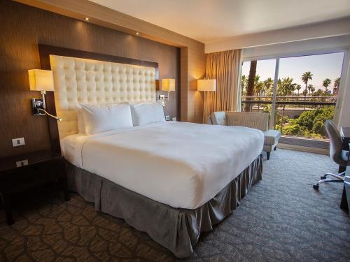 a hotel room with a large bed and a large window at Hotel Lucerna Mexicali in Mexicali