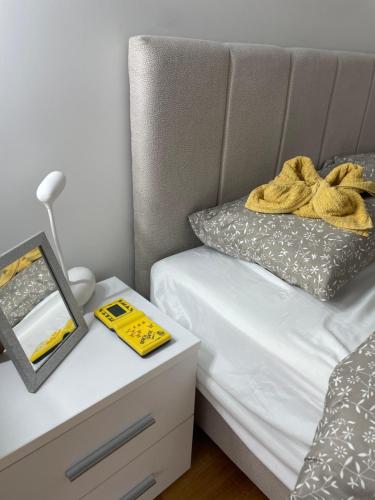 uma cama com uma toalha amarela ao lado de uma mesa de cabeceira em LAGATOR LUX em Loznica