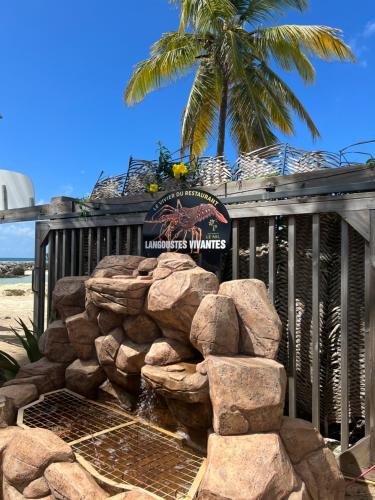 a sign for a hotel with a pile of rocks at Le NIL in Sainte-Anne