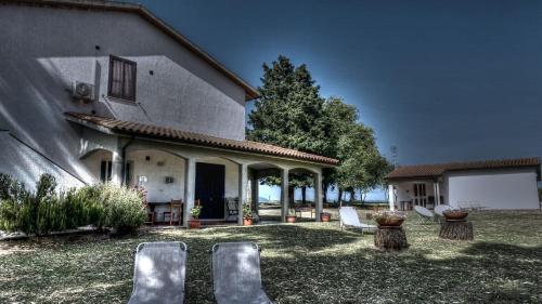 a group of chairs sitting outside of a house at Agriturismo Uliveto Gretacci in Montemerano