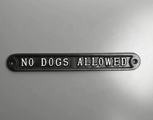 a no dogs allowed sign on a white wall at Simonstone Hall Hotel in Hawes
