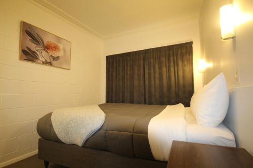 a hotel room with a bed and a table at Beach Lodge Motels in Dunedin