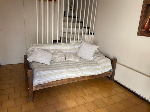 a wooden bench with pillows on it in a room at Departamento centrico con cochera! Excelente ubicación in Mendoza