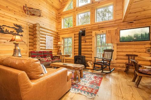 a living room with a couch and a fireplace in a log cabin at Big Log Lodge in McHenry