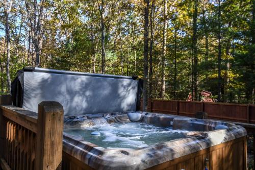 a hot tub on a deck with trees in the background at Keep Calm and Lake On in Swanton