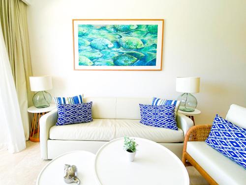 a living room with a couch and a painting on the wall at Xeliter Cana Rock Punta Cana in Punta Cana