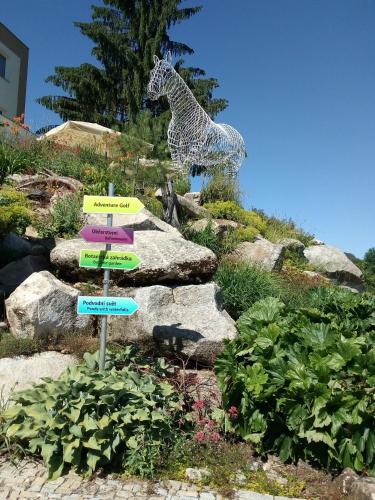 a statue of a giraffe in a garden with rocks at Apartman LEO Nr. 8 Lipno nad Vltavou in Lipno nad Vltavou