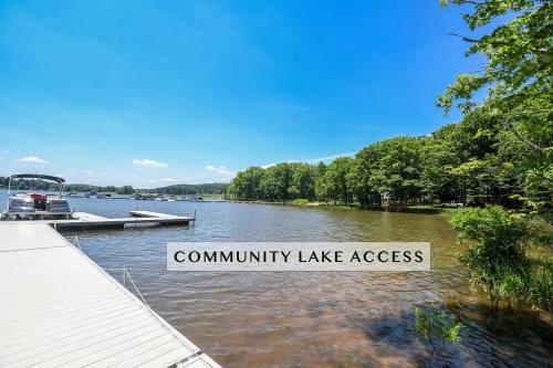 a lake with a dock and a boat on the water at Stilwater Serenity in Swanton