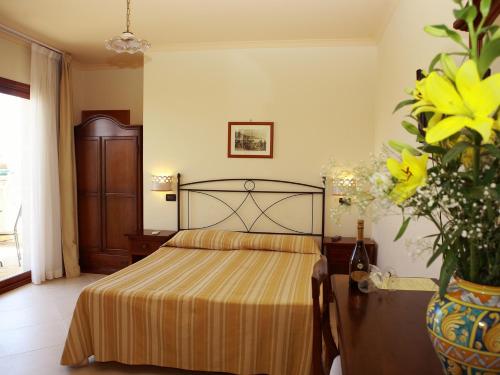 a bedroom with a bed and a vase of flowers at Villa Cristina in Giardini Naxos