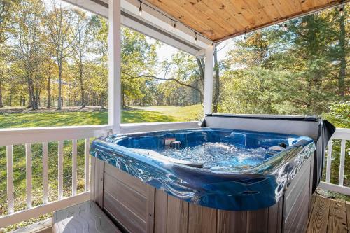 a hot tub on a porch with a window at Fore Seasons Getaway in McHenry