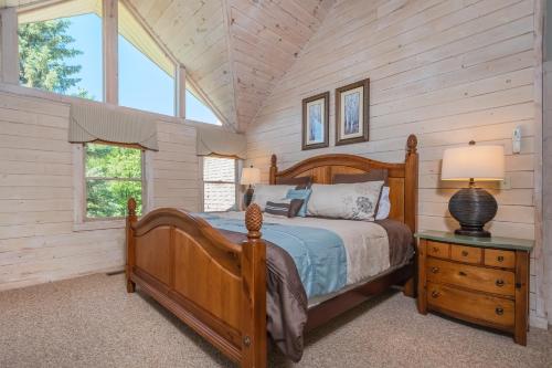 a bedroom with a wooden bed in a room with windows at Mallard Landing in McHenry