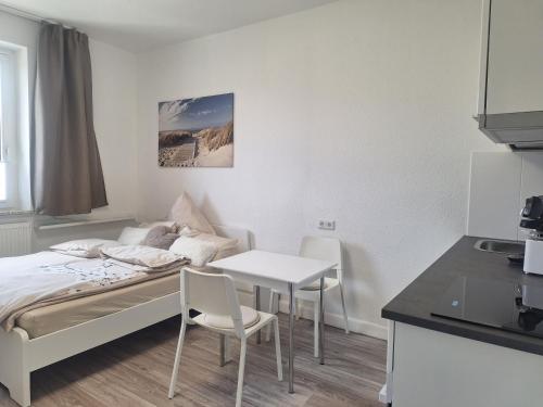 a bedroom with a bed and a table and chairs at Studio Apartment 17 - 2R2 in Essen