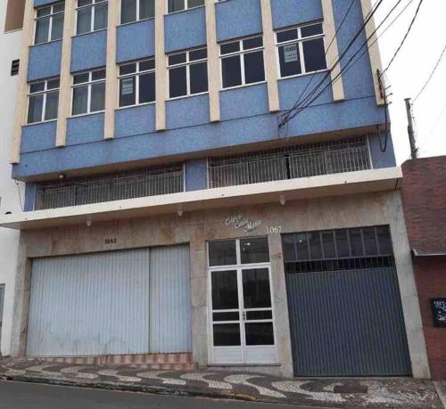 a blue building with two garage doors at Ap Central c/ Garagem in Ponta Grossa