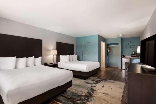 a hotel room with two beds and a bathroom at Richland Riverfront Hotel, Ascend Hotel Collection in Richland