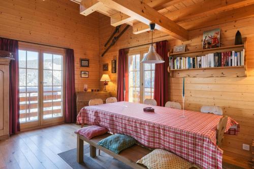 een eetkamer met een tafel en stoelen in een hut bij Montebello Cozy, classic Swiss chalet with stunning views in La Tzoumaz