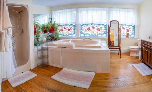 a bathroom with a tub and a toilet and a window at Heathwood Inn in Bar Harbor