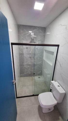 a bathroom with a glass shower and a toilet at Vila Leão do Norte in Japaratinga