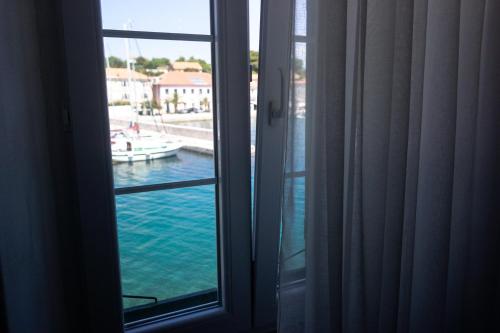 a window with a view of a boat in the water at Apartment Basioli in Sali
