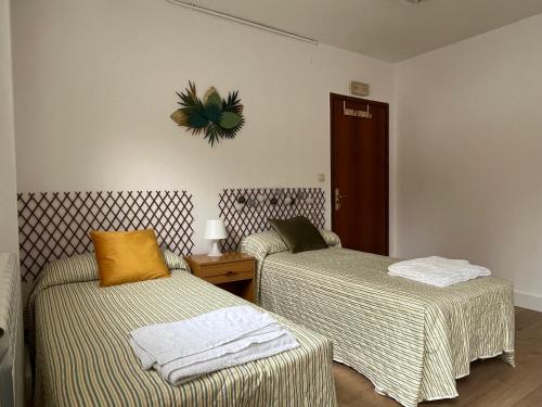 a room with two beds and a clock on the wall at RESISANTANDER - Apartamento para 9 personas in Santander