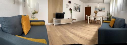 a living room with two blue couches and a television at RESISANTANDER - Apartamento para 9 personas in Santander