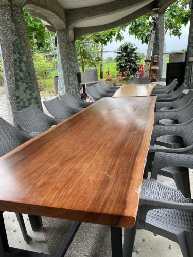 a long wooden table and chairs in a room at Ferry Head Leisure Club in Yuanshan