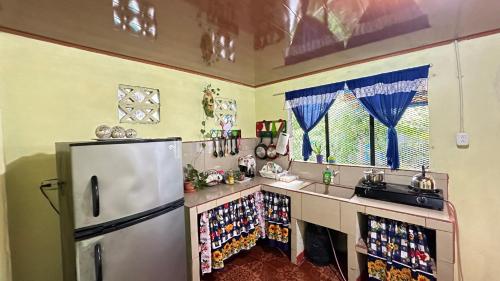 een keuken met een koelkast en een bar met drankjes bij The Corner House in Tortuguero
