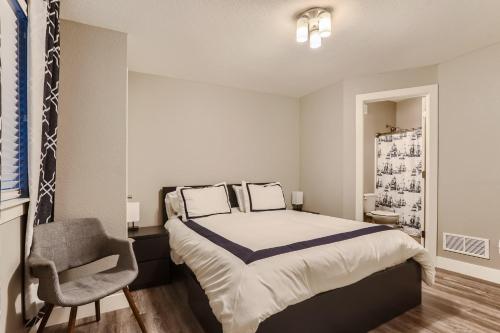 a bedroom with a bed and a chair in it at Central Park - 28th Place Apt in Aurora