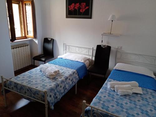 a room with two beds and two chairs in it at La Dimora di Pietra in Gubbio