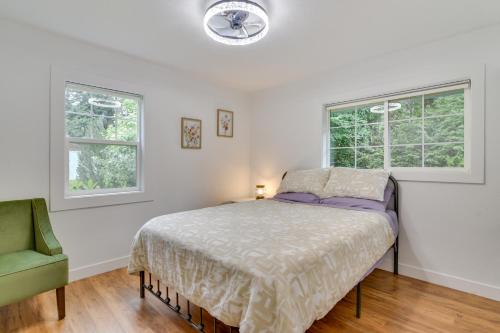a bedroom with a bed and two windows at Downtown Home with Patio - Walk to Shops and Dining! in Stevenson