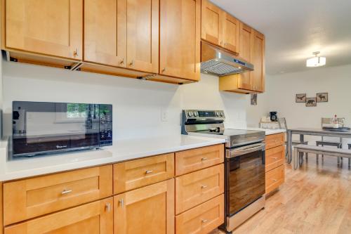 a large kitchen with wooden cabinets and appliances at Downtown Home with Patio - Walk to Shops and Dining! in Stevenson