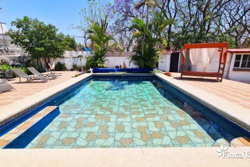 uma piscina com azulejos azuis e verdes num quintal em Finca Taino. Hermosa casa con alberca em Jiutepec