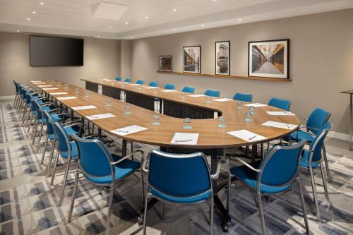 a large conference room with a long table and blue chairs at Le Méridien Paris Arc De Triomphe in Paris