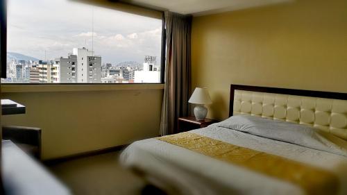 a bedroom with a bed and a large window at Edificio Akros in Quito