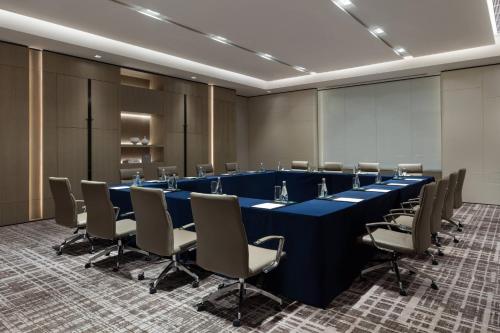 a conference room with a long blue table and chairs at Courtyard by Marriott Shenzhen Northwest in Bao'an