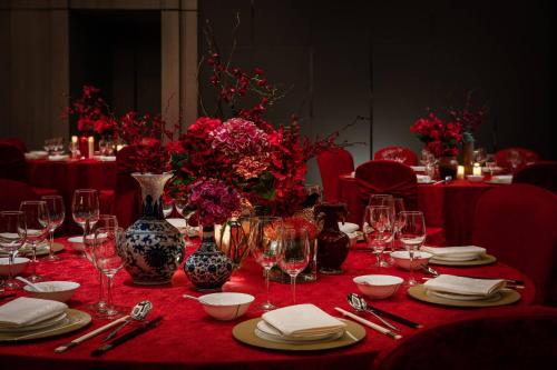a table with a red table cloth with wine glasses and flowers at Courtyard by Marriott Shenzhen Northwest in Bao'an