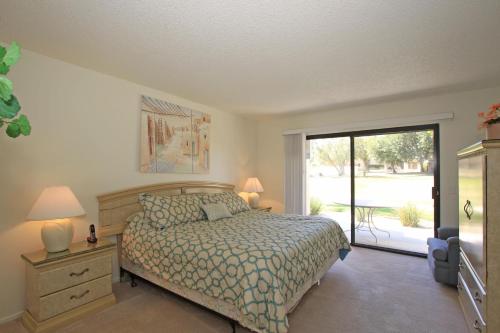 een slaapkamer met een bed en een glazen schuifdeur bij P1807 - Costa Circle in Palm Desert
