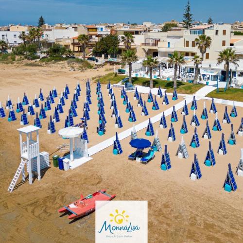 a bunch of blue umbrellas and chairs on a beach at Mare Nostrum TF in Tre Fontane