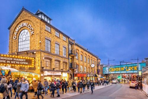 a crowd of people walking down a street in front of a building at 18K HOME FROM HOME in London