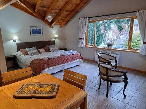 Un dormitorio con una cama y una mesa y sillas. en Las Golondrinas - UF 319, en San Martín de los Andes